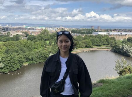 images of Judy on fromt of a lake and cityscape in background