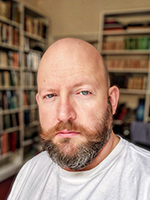 head and shoulders of Rich infront of bookshelves