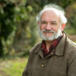 head and shoulders with blurred greenery in the backgroud