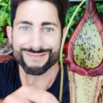 Smiling face of Chris with flower