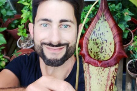 Smiling face of Chris with flower