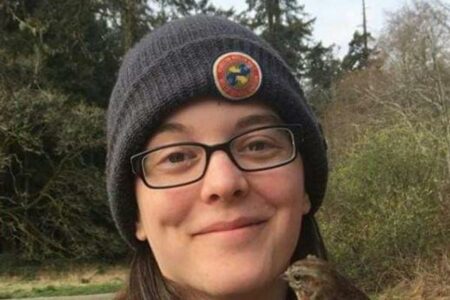 head shot of waman wearing glasses with a hat on