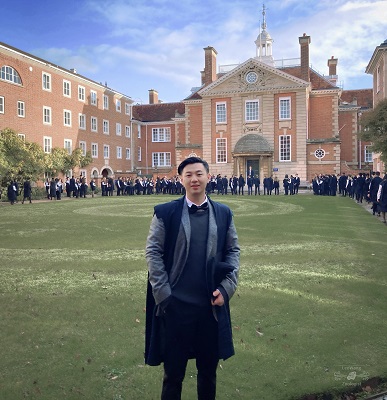young man in subfast stands in a quad looking at camera